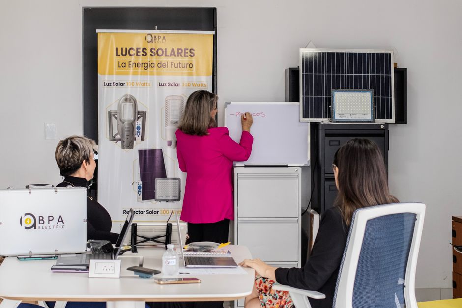 A team engaged in brainstorming solar energy solutions with panels and a whiteboard in an office.